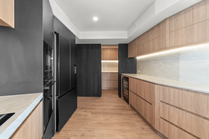 Custom cabinetry and stone surfaces in the completed Main Beach kitchen